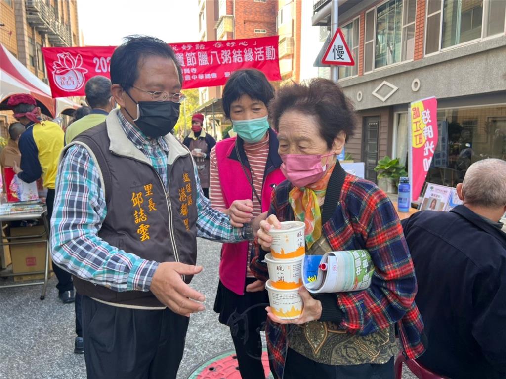 港都里里長邱誌雲協助里民領取臘八粥。.jpg