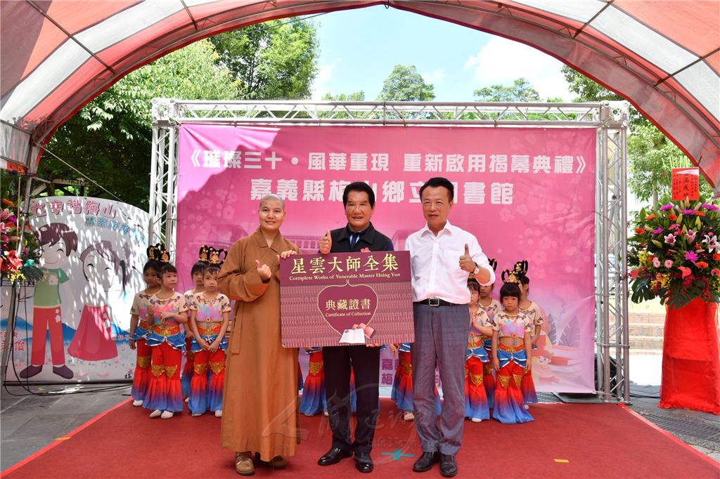 5月19日梅山鄉圖書館整修啟用典禮中，舉行隓重的贈書典禮，如君法師與嘉義縣長翁章梁（右）、與梅山鄉長林