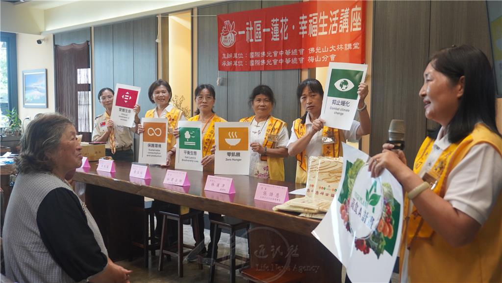 梅山分會督導林宥瑩(右1)於講座開始前，向村民推廣蔬食Ａ計劃。.jpg